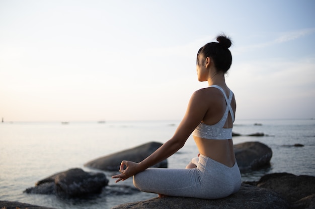 Asiatische mädchen praxis yoga am strand sunrise morgentag