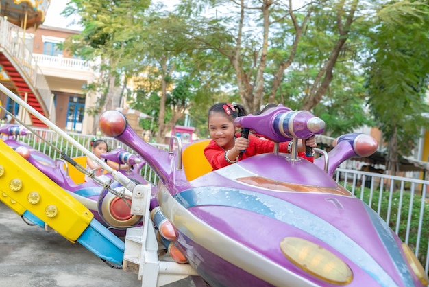 Asiatische Mädchen spielen auf dem Spielplatz mit Spaß Glückliche Zeit des Kindes