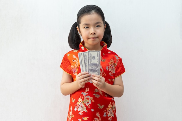 Asiatische Mädchen tragen Cheongsam und nehmen Banknote im chinesischen Neujahr