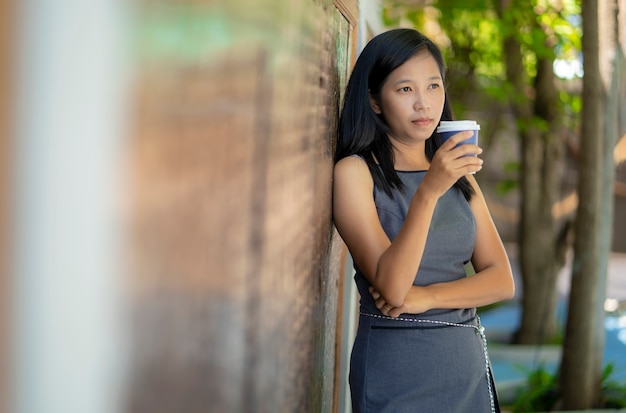 Asiatische Mädchen trinken heißen Kaffee in der Kaffeestube