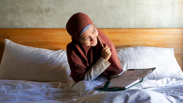 Asiatische Mädchenanmerkungen auf dem Bett