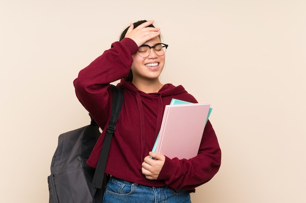 Asiatische Mädchenfrau des jungen Studenten über dem lokalisierten Wandlachen