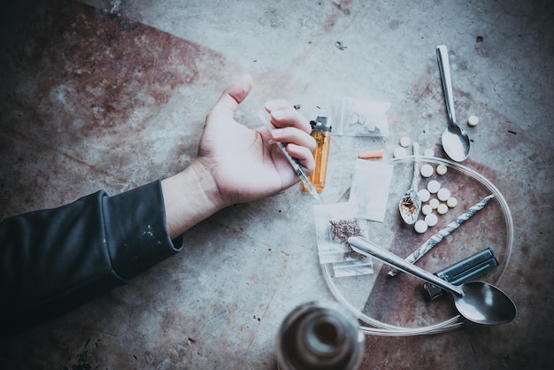 Foto asiatische männer sind drogensüchtig, um sich selbst heroin in die adern zu spritzen flakka-droge oder zombie-droge ist lebensgefährlichthailand nein zum drogenkonzeptder bösewicht drogen in der einöde