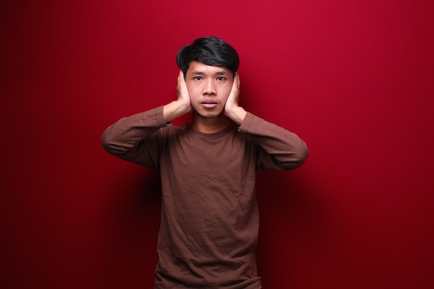 asiatische Männer tragen braune T-Shirts, die ihre Ohren bedecken