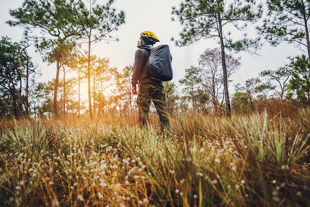 Asiatische Mann Reise Natur. Reisen entspannen. Rucksack wandern auf der Wiese im Wald. Thailand