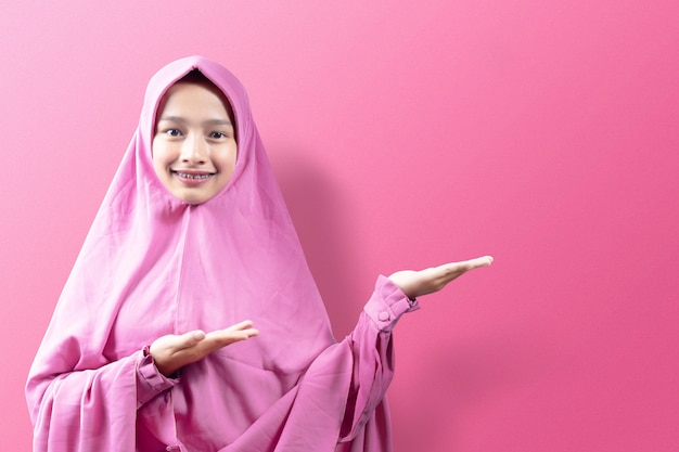 Asiatische muslimische Frau in einem Schleier, der offene Handfläche zeigt