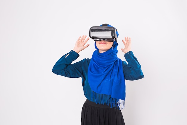 Asiatische muslimische Frau mit Hijab mit VR-Headset-Brille der virtuellen Realität auf weißem Hintergrund.