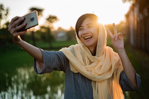 Asiatische muslimische Frau nehmen Selfie mit Handy