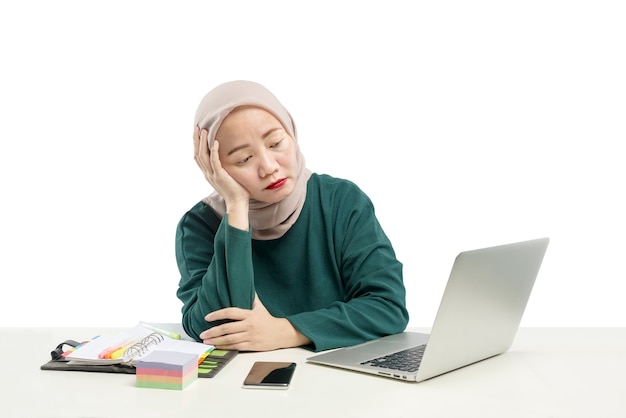 Asiatische muslimische Geschäftsfrau, die einen Laptop verwendet, der von zu Hause lokalisiert über weißem Hintergrund arbeitet. Grippeerkrankung Coronavirus vorbeugen