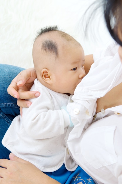 Asiatische Mutter, die ihr Baby stillt