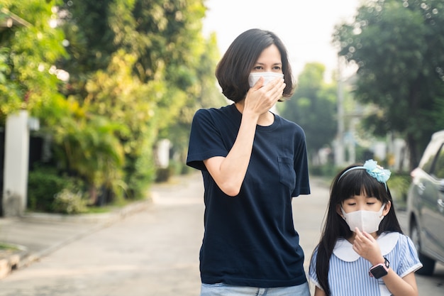 Asiatische Mutter Frau und kleine junge Mädchen Tochter tragen Maske, um Covid-19 zu verhindern