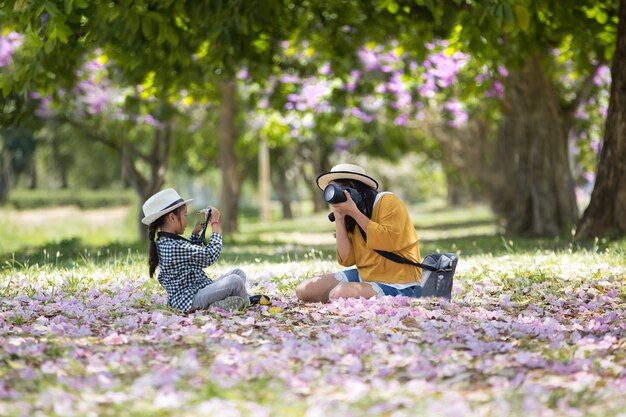 Asiatische Mutter und Tochter, die zusammen Foto im Park macht