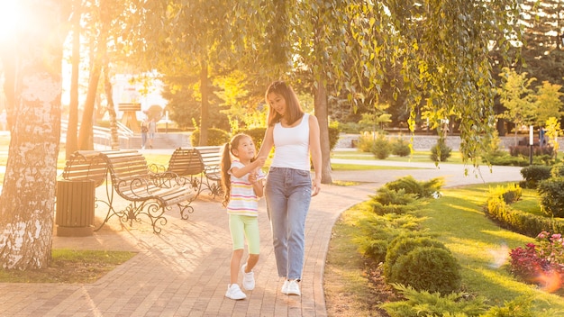 Asiatische Mutter und Tochter, die zusammen im Park gehen