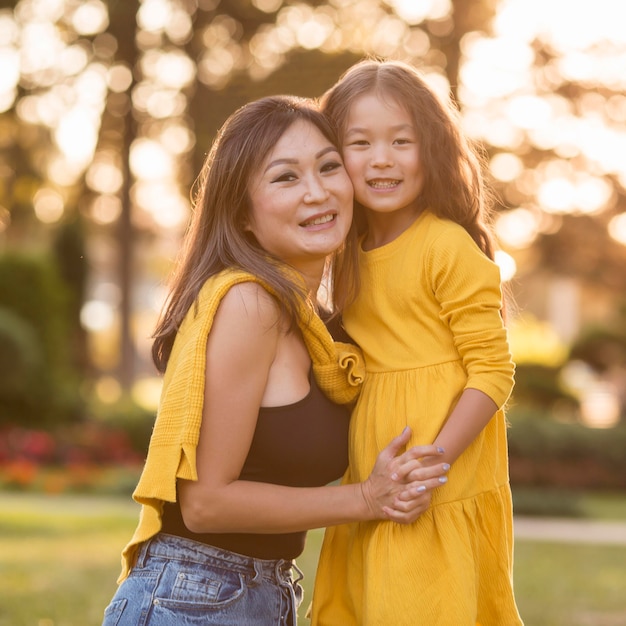 Asiatische Mutter und Tochter Händchen haltend