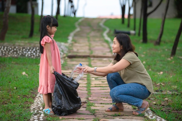 Asiatische Mutter und Tochter helfen bei der Müllabfuhr