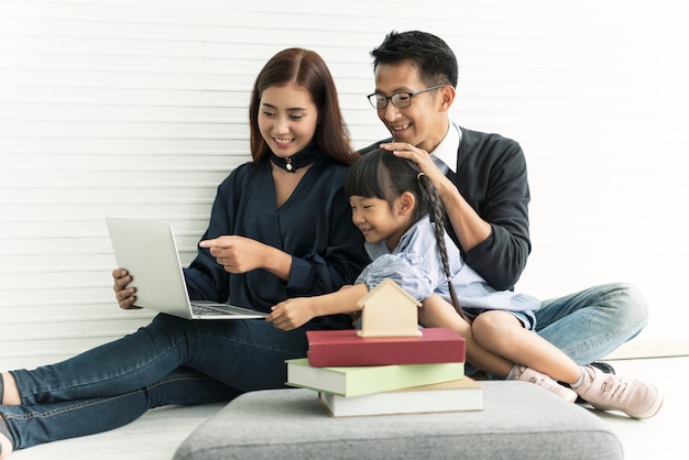 Asiatische Mutter und Vater der Familie mit der Tochter glücklich zusammen im Wohnzimmer zu Hause.