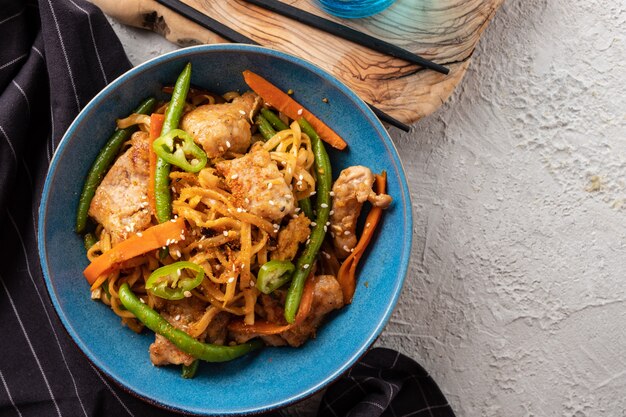 Asiatische Nudeln mit Schweinefleisch in Teriyaki-Sauce, mit grünen Bohnen, Karotten und Shiitake-Pilzen.