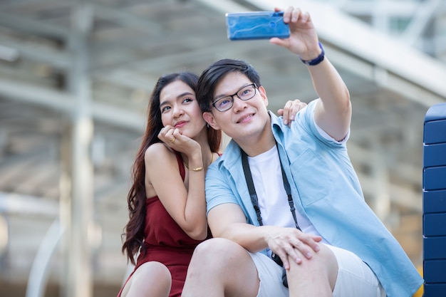 Asiatische Paarliebe fotografieren mit dem Handy auf der Straße