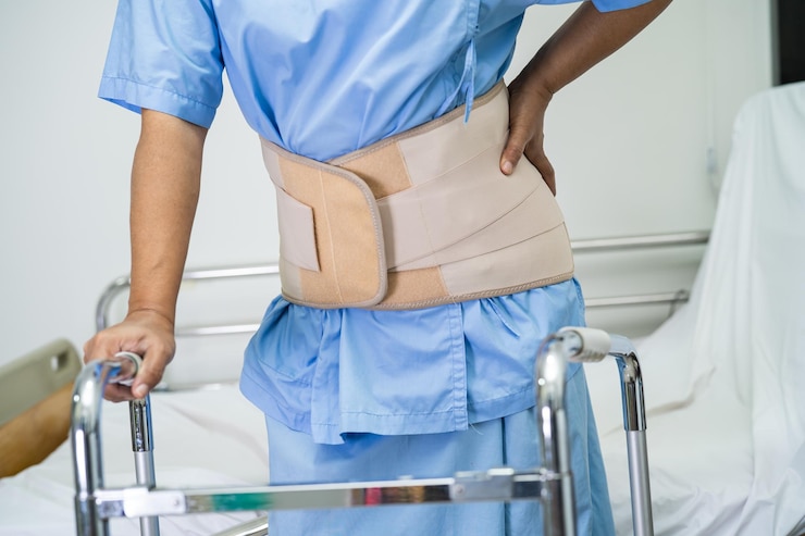 Foto asiatische patientin mit rückenschmerz-stützgürtel für die orthopädische lendenwirbelsäule mit gehhilfe