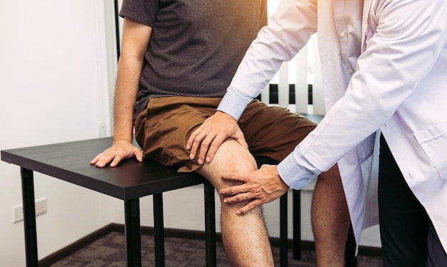 Asiatische Physiotherapeuten überprüfen die Knie der Patienten
