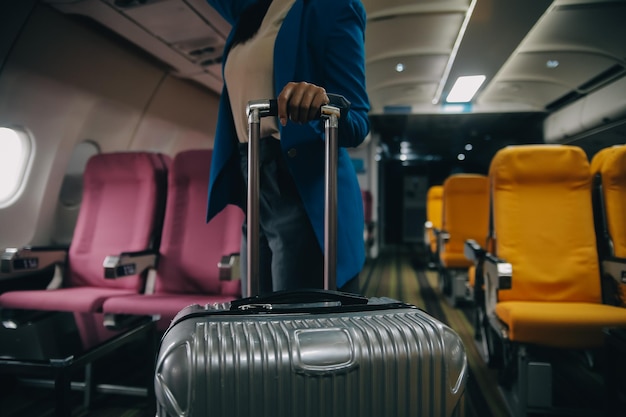 Foto asiatische reisende, die während des einstiegs ihr gepäck in den flugzeugschrank legt