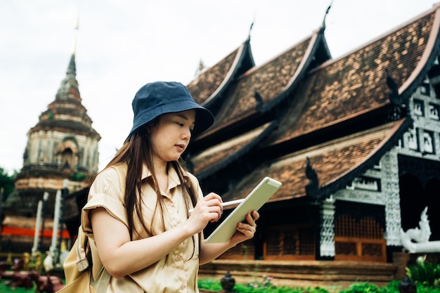 Asiatische Reisende mit Tablette im Ok Moli-Tempel in der Provinz Chiang Mai, Thailand