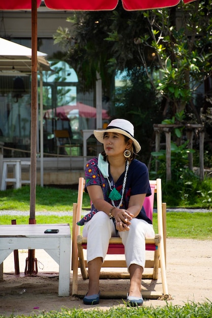 Asiatische Reisende thailändische Frauen reisen besuchen und sitzen entspannt auf Liegestühlen oder Liegestühlen am kleinen Strand im Gartenpark im Freien des Café-Restaurant-Coffee-Shops in Bangkok, Thailand