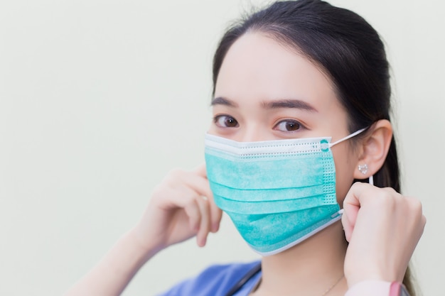 Asiatische Ärztin trägt medizinische Gesichtsmasken zum Schutz vor Coronavirus19 COVID19