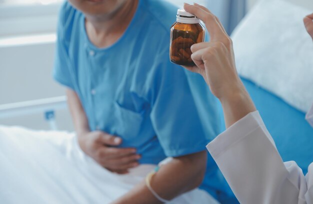 Asiatische Ärztinnen halten die Hand des Patienten und ermutigen und geben medizinische Ratschläge, während sie die Gesundheit des Patienten im Bett überprüfen Konzept der Pflege und des Mitgefühls Schwangerschaftsvorsorge Drohende Abtreibung