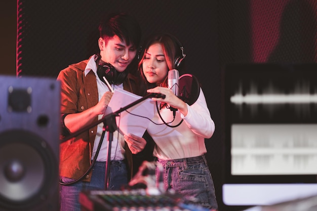 Foto asiatische sängerpaare in einem aufnahmestudio mit einem studiomikrofon mit leidenschaft im musikaufnahmestudio