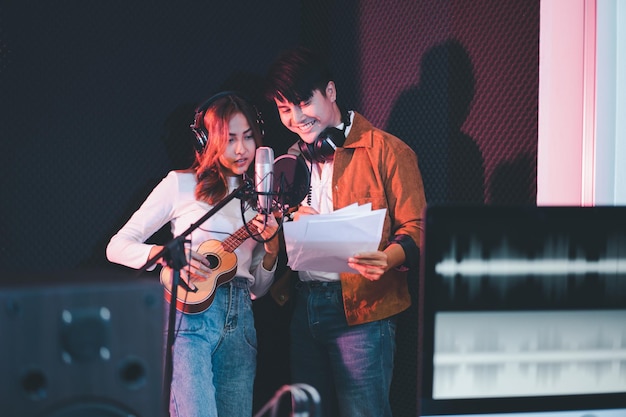 Asiatische sängerpaare in einem aufnahmestudio mit einem studiomikrofon mit leidenschaft im musikaufnahmestudio