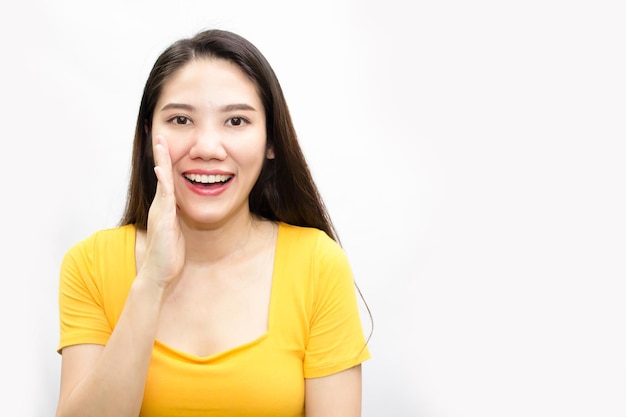 Asiatische schöne Frau trägt grünes T-Shirt und erzählt oder flüstert ein Geheimnis für Neuigkeiten und Informationen