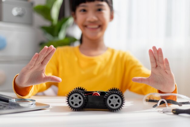 Asiatische Schüler lernen zu Hause in der Programmierung von Roboter-Autos und elektronischen Plattenkabeln in STEM STEAM Mathematik Ingenieurwissenschaften Technologie Computer-Code in Robotik für Kinder Konzept