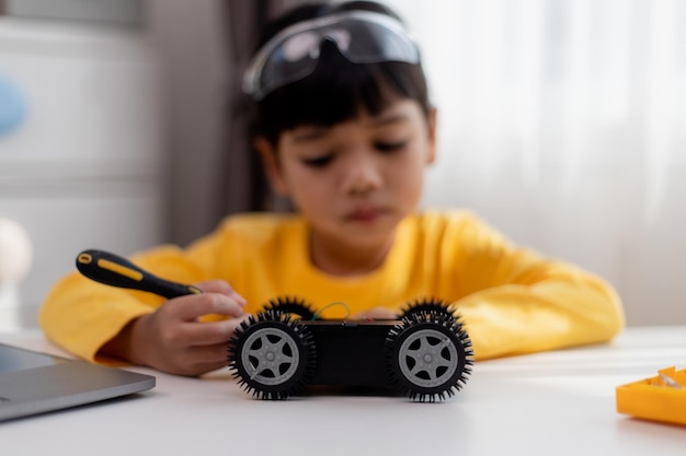 Asiatische Schüler lernen zu Hause in der Programmierung von Roboter-Autos und elektronischen Plattenkabeln in STEM STEAM Mathematik Ingenieurwissenschaften Technologie Computer-Code in Robotik für Kinder Konzept