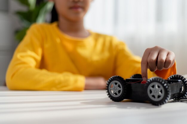 Asiatische Schüler lernen zu Hause in der Programmierung von Roboter-Autos und elektronischen Plattenkabeln in STEM STEAM Mathematik Ingenieurwissenschaften Technologie Computer-Code in Robotik für Kinder Konzept