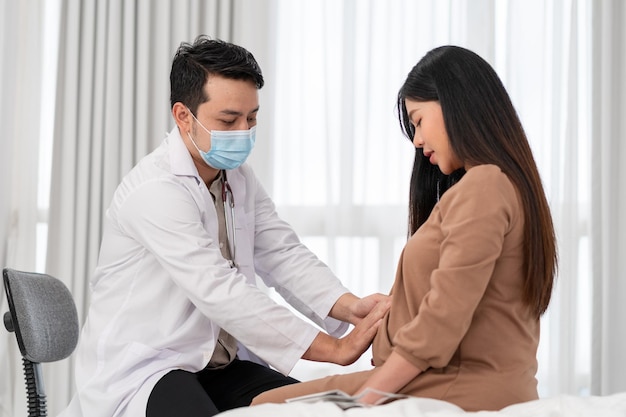 Foto asiatische schwangere frau besucht gynäkologen im krankenhaus für schwangerschaftsberater