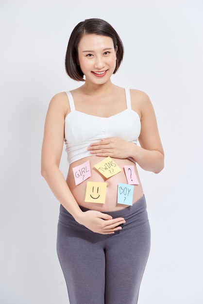 Asiatische schwangere Frau mit Haftnotiz auf dem Bauch