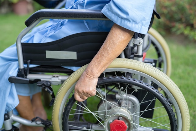 Asiatische Seniorin oder ältere Patientin der alten Dame auf Elektrorollstuhl mit Fernbedienung auf Krankenstation gesundes, starkes medizinisches Konzept