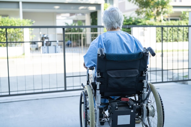 Asiatische Seniorin oder ältere Patientin der alten Dame auf Elektrorollstuhl mit Fernbedienung auf Krankenstation gesundes, starkes medizinisches Konzept