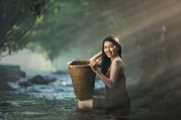 Asiatische sexy Frau, die in der Kaskade, Thailand badet