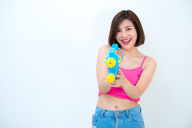 Asiatische sexy Frau mit Pistolenwasser in der Hand auf weißem HintergrundFestival Songkran Tag in ThailandDas beste Festival von ThailandLand des Lächelns