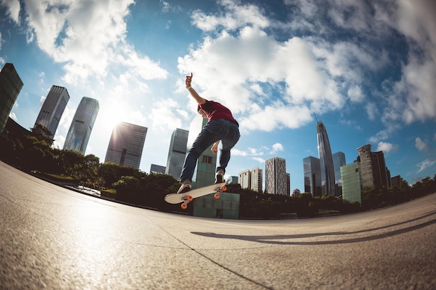 Asiatische Skateboarderin fährt Skateboard in der modernen Stadt