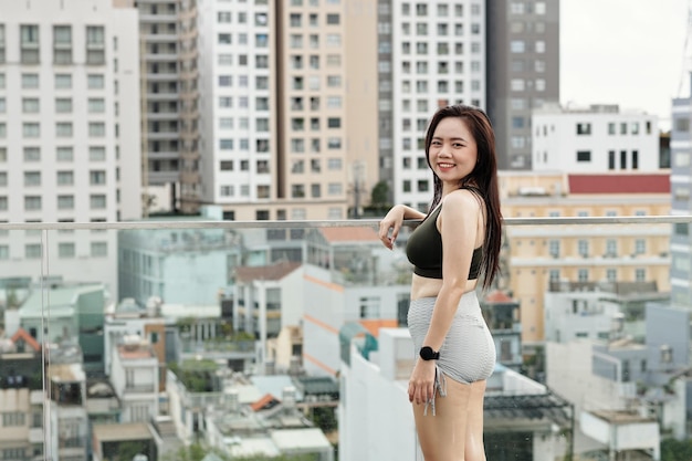 Asiatische Sportlerin, die auf Dachspitze steht