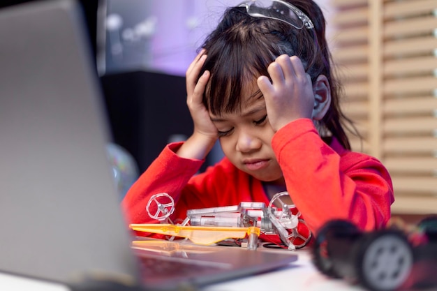 Asiatische Studenten lernen zu Hause in der Codierung von Roboterautos und elektronischen Platinenkabeln im MINT-DAMPF-Mathematik-Ingenieurwissenschaften-Technologie-Computercode im Robotik-Konzept für Kinder