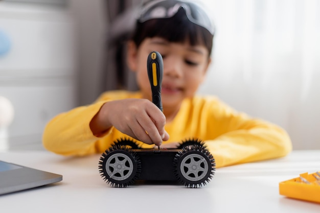 Asiatische Studenten lernen zu Hause in der Codierung von Roboterautos und elektronischen Platinenkabeln im MINT-DAMPF-Mathematik-Ingenieurwissenschaften-Technologie-Computercode im Robotik-Konzept für Kinder