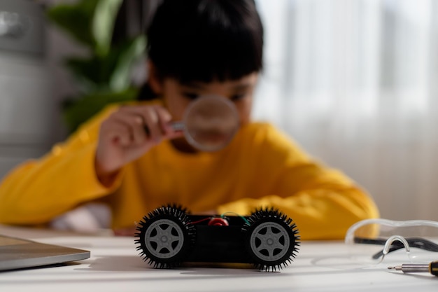 Asiatische Studenten lernen zu Hause in der Codierung von Roboterautos und elektronischen Platinenkabeln im MINT-DAMPF-Mathematik-Ingenieurwissenschaften-Technologie-Computercode im Robotik-Konzept für Kinder