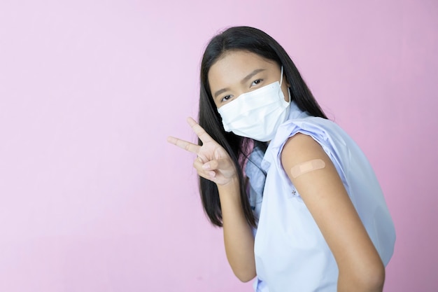 Asiatische Studentenimpfung auf rosa Hintergrund.