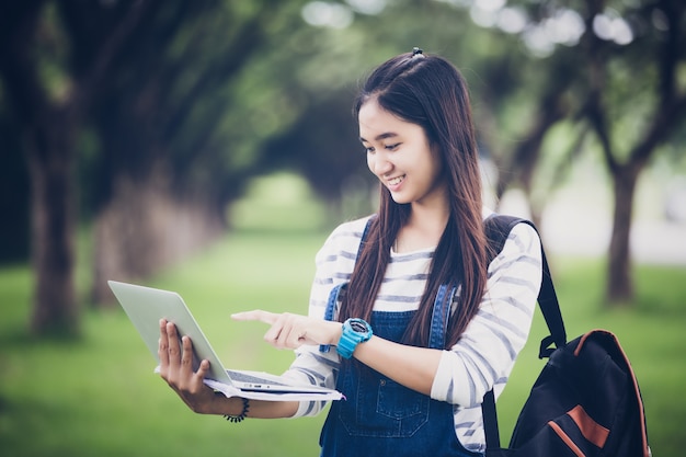 Asiatische Studentin, die Bücher hält