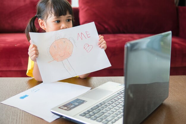 Asiatische Studentin Online-Lernklasse Studieren Sie online mit Laptop zu Hause.