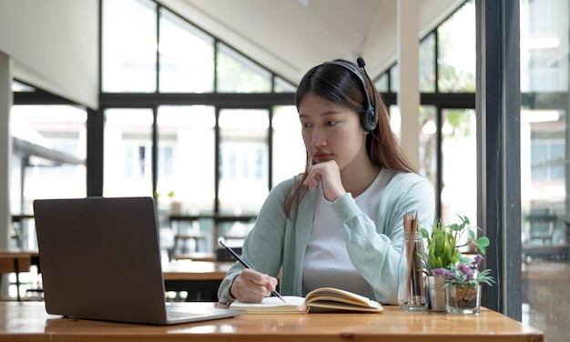 Asiatische Studentin Videokonferenz E-Learning mit Lehrer am Computer im Wohnzimmer zu Hause E-Learning-Online-Bildung und soziale Distanzierung im Internet schützen vor COVID19-VirenxA